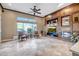 Spacious living room features a cozy fireplace and built-in cabinets and large windows with outdoor views at 42023 N Bridlewood Way, Anthem, AZ 85086