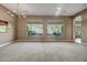 Spacious living room with a chandelier, large windows offering serene views, and plush carpeting at 42023 N Bridlewood Way, Anthem, AZ 85086