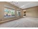 Bright living room with large windows offering outdoor views, carpet, and neutral walls at 42023 N Bridlewood Way, Anthem, AZ 85086