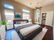 Modern bedroom with dark-wood flooring, a king bed, and large windows offering plenty of natural light at 42023 N Bridlewood Way, Anthem, AZ 85086