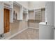 A spacious walk-in closet with white shelving, drawers, and stylish wood paneling at 42023 N Bridlewood Way, Anthem, AZ 85086