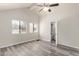 Bright bedroom featuring wood floors, neutral walls, and a ceiling fan, adjacent to a private bathroom at 4901 S Calle Los Cerros Dr # 220, Tempe, AZ 85282