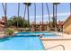 Community pool surrounded by tall palm trees, lounge chairs, and a jacuzzi at 4901 S Calle Los Cerros Dr # 220, Tempe, AZ 85282