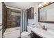 Bathroom showcasing decorative stone tile in the bath and shower with dark wood vanity at 5133 E Keresan St, Phoenix, AZ 85044