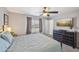 Cozy bedroom with natural light, ceiling fan and neutral decor with a dresser at 5133 E Keresan St, Phoenix, AZ 85044