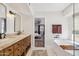 Luxurious bathroom showcasing a double vanity, tub, and entrance to the bedroom at 5556 E Sandra Ter, Scottsdale, AZ 85254