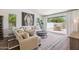 Bright living room with a view to the patio through glass doors, featuring a sectional and horse painting at 5556 E Sandra Ter, Scottsdale, AZ 85254
