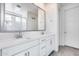 Stylish bathroom features double vanity sinks with quartz countertops, a large mirror, and white cabinets at 651 N Bay Dr, Gilbert, AZ 85233