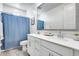 Bathroom featuring double sink vanity, large mirror, and shower with blue curtain at 651 N Bay Dr, Gilbert, AZ 85233