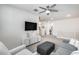 Bright, open living room with grey sofa and ottoman, TV, and staircase at 651 N Bay Dr, Gilbert, AZ 85233