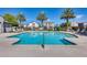 Large community pool surrounded by lounge chairs and palm trees, with residential buildings in the background at 651 N Bay Dr, Gilbert, AZ 85233