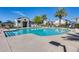 Sunny community pool area with lounge chairs and clear water, perfect for relaxation and recreation at 651 N Bay Dr, Gilbert, AZ 85233
