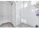 Modern shower with white subway tile surround, glass door, and neutral tile flooring at 651 N Bay Dr, Gilbert, AZ 85233