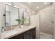 Modern bathroom featuring dual sinks, a dark wood vanity, and a beautifully tiled walk-in shower at 6732 W Sack Dr, Glendale, AZ 85308