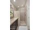Bright bathroom with a walk-in shower featuring light-colored tiling and a dark vanity at 6732 W Sack Dr, Glendale, AZ 85308