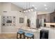 Kitchen island with barstool seating features granite countertops, a stainless steel refrigerator, and ample storage space at 6732 W Sack Dr, Glendale, AZ 85308