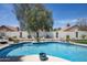 Inviting backyard pool featuring manicured landscaping, a white textured privacy wall, and a refreshing atmosphere at 6732 W Sack Dr, Glendale, AZ 85308