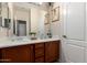 Well-lit bathroom with double vanity, wood cabinets, framed art, and a convenient doorway at 7241 W Donner Dr, Laveen, AZ 85339