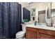 Cozy bathroom featuring a blue shower curtain, modern vanity, mirror and decorative touches at 7241 W Donner Dr, Laveen, AZ 85339
