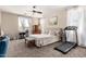 Spacious bedroom with neutral tones features a ceiling fan, dressers, and a treadmill at 7241 W Donner Dr, Laveen, AZ 85339