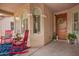 Inviting front porch with rocking chairs, decorative plants, and a charming wooden front door at 7241 W Donner Dr, Laveen, AZ 85339