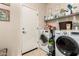 Laundry room with washer, dryer, storage shelves, tiled flooring, and a utility sink at 7241 W Donner Dr, Laveen, AZ 85339