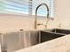 Close-up of the kitchen sink featuring stainless steel and a gold faucet at 733 E Megan Dr, San Tan Valley, AZ 85140