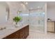 Luxurious bathroom with double vanity, decorative tile and a glass-enclosed shower with dual showerheads at 7348 N 9Th Pl, Phoenix, AZ 85020