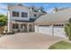 Elegant white home featuring a large driveway, three-car garage, manicured lawn, and a charming front porch at 7348 N 9Th Pl, Phoenix, AZ 85020