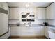 Bright, open kitchen featuring white cabinets and countertops, with a modern lighting fixture at 7348 N 9Th Pl, Phoenix, AZ 85020