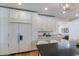A kitchen featuring a refrigerator and a view to a living area with a white kitchen color scheme at 7348 N 9Th Pl, Phoenix, AZ 85020