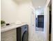 Modern laundry room with washer, countertop, and tile flooring near the entry to the walk-in closet at 7348 N 9Th Pl, Phoenix, AZ 85020