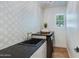 Charming laundry room with patterned wallpaper, black sink, and modern appliances at 7348 N 9Th Pl, Phoenix, AZ 85020