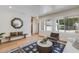 Bright living room with light hardwood floors, two large windows, a decorative mirror, and stylish furniture at 7348 N 9Th Pl, Phoenix, AZ 85020