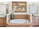 Elegant bathroom with a soaking tub, decorative tile, and framed mirrors at 7601 E Indian Bend Rd # 3030, Scottsdale, AZ 85250