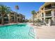 Beautiful pool with turquoise water, lounge chairs, and palm trees surrounded by multi-story apartment buildings on a sunny day at 7601 E Indian Bend Rd # 3030, Scottsdale, AZ 85250