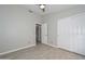 Well-lit bedroom with light gray walls, hardwood floors, closet, and an open ensuite bathroom at 7949 W Wescott Dr, Glendale, AZ 85308