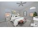 Light and airy bedroom with neutral tones, a decorative mirror, and a ceiling fan at 7949 W Wescott Dr, Glendale, AZ 85308