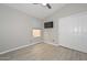 Bright, streamlined bedroom with wood flooring, closet, window, and wall-mounted TV at 7949 W Wescott Dr, Glendale, AZ 85308