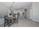 Inviting dining area next to an updated kitchen boasts wood-look tile floors, gray walls, and stylish light fixtures, creating a cozy space at 7949 W Wescott Dr, Glendale, AZ 85308