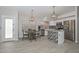 Open concept dining and kitchen space features stylish light fixtures, wood-look tile flooring, and white cabinets at 7949 W Wescott Dr, Glendale, AZ 85308