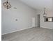 Bright living room boasts high ceilings, light gray walls, wood-look tile floors, and modern lighting fixtures, creating a stylish space at 7949 W Wescott Dr, Glendale, AZ 85308