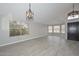 Spacious living room featuring light gray walls, wood-look tile floors, and ample natural light through large windows, for modern living at 7949 W Wescott Dr, Glendale, AZ 85308