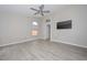 Spacious primary bedroom features ceiling fan, wood-look tile flooring, and neutral paint at 7949 W Wescott Dr, Glendale, AZ 85308