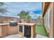 Outdoor kitchen with a built-in grill, mini-fridge, counter space, and manicured faux grass at 7949 W Wescott Dr, Glendale, AZ 85308