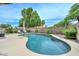Beautiful kidney-shaped pool surrounded by lush landscaping and a spacious patio at 7949 W Wescott Dr, Glendale, AZ 85308