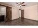 A large bedroom featuring wood look floors, a ceiling fan and barn doors to the bathroom at 8542 N 30Th Dr, Phoenix, AZ 85051