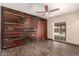 A spacious bedroom with a wood accent wall, wood-look floors and a fan light fixture at 8542 N 30Th Dr, Phoenix, AZ 85051