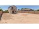A large empty backyard with brick perimeter fence and covered patio at 8577 S 253Rd Dr, Buckeye, AZ 85326