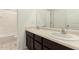 Bathroom featuring double sinks with light countertops and dark cabinetry at 8577 S 253Rd Dr, Buckeye, AZ 85326